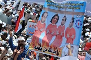 المتظاهرون يرفعون صورة للرئيس السابق وعائلته في التحرير للمطالبة بسرعة محاكمتهافپ