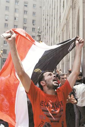 احد المعتصمين يرفع العلم المصري في التحرير	افپ﻿