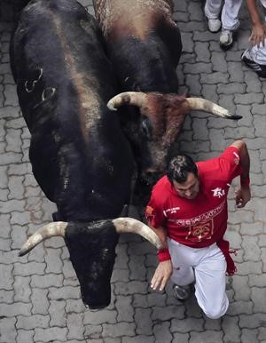 احد المشاركين في المهرجان يفر من الثيران﻿