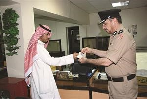 المقدم بدر الفيلكاوي يسلم الجنسية لاحد المتجنسين الجدد﻿