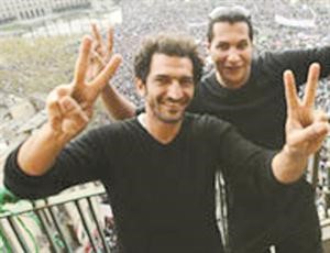 ويشير بيده بعلامة النصر
