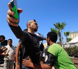 احد افراد اللجان الشعبية يقوم بتفتيش متظاهر قبل السماح له بالدخول للاعتصام في الاسكندرية امس رويترز﻿