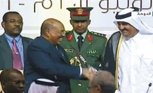 صورة عن التلفزيون للرئيس السوداني عمر البشير مصافحا امير قطر الشيخ حمد بن خليفة لشكره على الوساطة القطرية خلال التوقيع على اتفاق سلام دارفور﻿