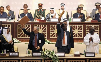 ممثلا الرئيس السوداني وحركة التعديل والعدالة يرفعان نسخة من الاتفاق بعد التوقيع عليه بحضور امير قطر الشيخ حمد بن خليفة ال ثاني وعدد من رؤساء افريقيارويترز