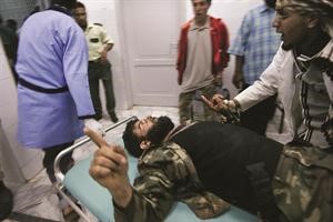 مسعفون يحاولون انقاذ احد الثوار اصيب في معارك البريقة امس الاول افپ