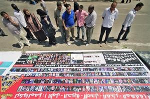 متظاهرون يطالعون صور القتلى الذين سقطوا في مواجهات مع الشرطة خلال الثورة 	اپ﻿