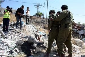 جنود اسرائيليون يعتدون على متظاهر فلسطيني في بلدة بيت عمر في الضفة الغربية 	رويترز﻿