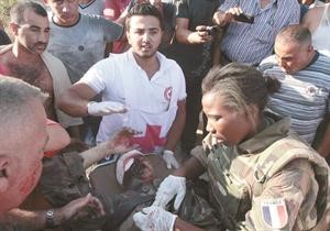عناصر فرنسية في اليونفيل والصليب الاحمر اللبناني يعالجون احد جرحى تفجير صيدا امس اپ