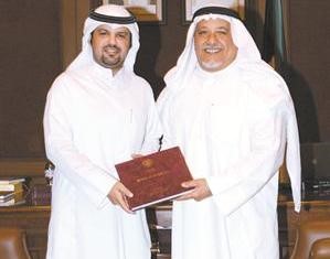 الشيخ علي الجراح يتسلم الكتاب من محمد المشعان
