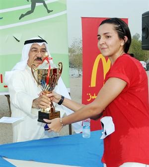 علي اليوسف يسلم الكاس لاحدى الفائزات
