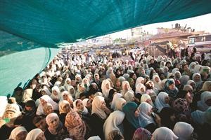 فلسطينيات ينتظرن للعبور نحو الاقصى لاداء صلاة الجمعة الاولى في رمضان عند حاجز قلنديا اپ