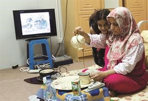 لاجئة ليبية من بنغازي تتحضر للافطار في مخيم قرب طرابلس 	 رويترز﻿