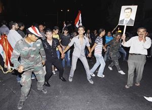 جنود ومؤيدون للرئس السوري يرقصون خلال مسيرة مؤيدة في دمشق	اپ﻿