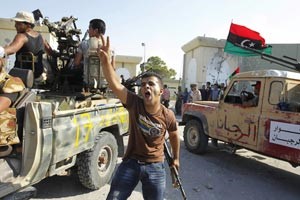 احد الثوار يشير بعلامة النصر بعد دخول باب العزيزية