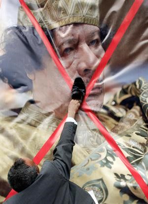 احد المواطنين الليبيين يضع الحذاء على وجه القذافي