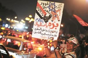 مصريون يحملون لافتات تطالب بطرد السفير الاسرائيلي فجر امس 	اپ﻿
