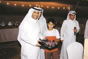 احد المشاركين في مسابقة حفظ القران الكريم يتسلم جائزته﻿
