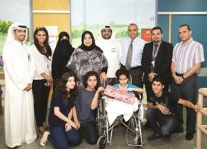 فريق العلاقات العامة ومتطوعي المستشفى في صورة جماعية مع الاطفال في مستشفى بنك الكويت الوطني﻿
