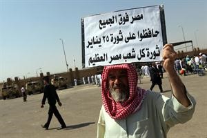 معارض للرئيس السابق حسني مبارك يرفع لافتة مؤيدة للثورة خارج المحكمة امس رويترز