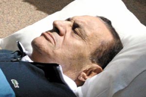 الرئيس المصري السابق مغمضا عينيه على سريره اثناء جلسة المحاكمة امس رويترز