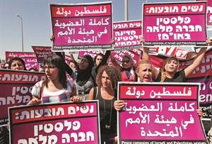 فلسطينيات واجنبيات يرفعن لافتات داعمة لاقامة دولة فلسطينية على حاجز قلنديا الاسرائيلي	رويترز﻿