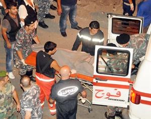 رجال الاسعاف ينقلون جثة احد ضحايا المجزرة