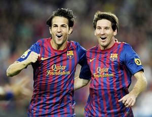 نجما برشلونة ليونيل ميسي وسيسك فابريغاس ويبدو شعار مؤسسة قطر على قميصهما افپ