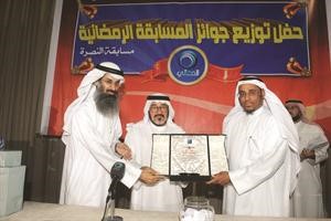 الزميل يوسف عبدالرحمن يتسلم درعا تكريمية من المعالي لـ الانباء