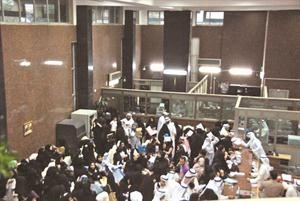 جموع من النسوة واهاليهن داخل بنك التسليف وسط فوضى وسوء تنظيم وفي الاطار صورة زنكوغرافية لاستمارة بحث قانون المراة