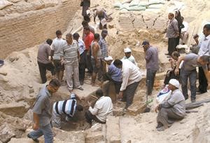 علماء اثار وعمال يفحصون موقع المقبرة الفرعونية الجديدة التي عثر عليها في عين شمس امس	افپ﻿