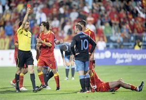 الحكم الالماني فولفغانغ يشهر البطاقة الحمراء في وجه مهاجم انجلترا واين روني وسط فرحة لاعبي مونتينيغرو افپ
