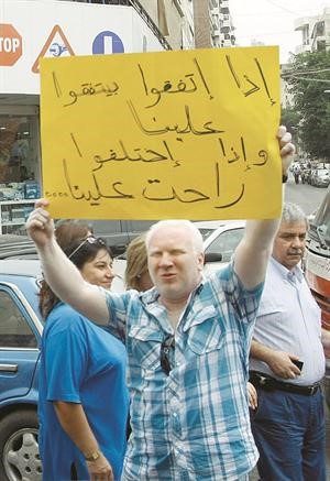 مواطن لبناني يرفع شعار مناهض للاتحاد العمالي العام بعد تعليق الاضراب محمود الطويل﻿