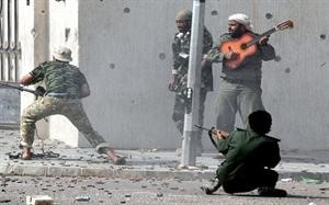القذافي يطلب من مؤيديه إشعال الحرائق في المؤسسات الليبية ويعرض نصف مليون دولار لمن يقتل مسؤولاً في «الانتقالي»!.. وثائر ليبي يعزف الغيتار على صوت الرصاص! 
