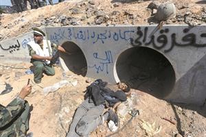 فتحة صرف المياه التي حاول القذافي الاختباء فيها وتبدو جثة احد مرافقيه افپ