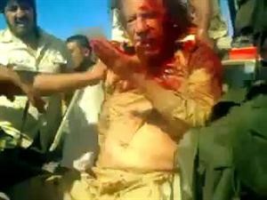 القذافي مضرجا بالدماء يتلقى الصفعات على وجهه من الثوار الذين اعتقلوه قبل قتله امس الاول 	رويترز﻿