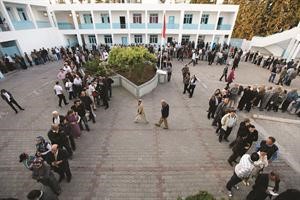 طوابير من الناخبين ينتظرون دورهم للادلاء باصواتهم في احدى محطات الاقتراع في تونس 	رويترز﻿