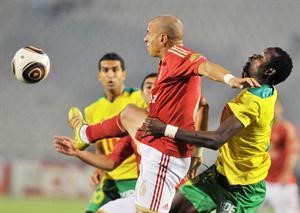 مدافع الاهلي وائل جمعة يبعد الكرة امام الغاني صامويل اترام

