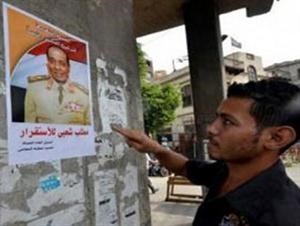 مصري يعاين احد الملصقات التي تدعو لترشيح المشير حسين طنطاوي	العربيةنت﻿