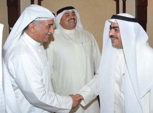 روضان الروضان مصافحا شعيب المويزري ويبدو المطير مبتسما