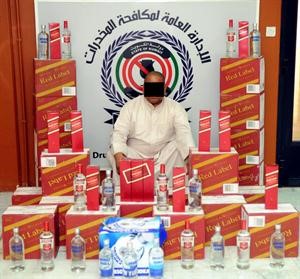 المتهم العراقي وامامه الخمور المضبوطه﻿