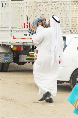 يحمي ابنه من ماء المطر في طريقه للمسجد﻿
