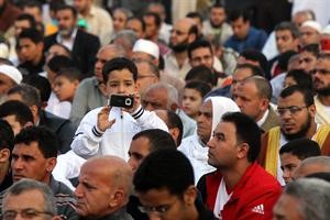 طفل يقوم بتصوير المصلين في مسجد بالمنصورة في صلاة عيد الاضحى امس افپ
