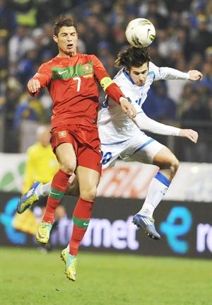 مهاجم البرتغال كريستيانو رونالدو في صراع فضائي على الكرة مع مدافع البوسنة زاهيروفيتش افپ