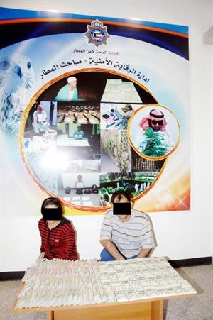 المتهمان وامامهما الملايين المسروقة 
