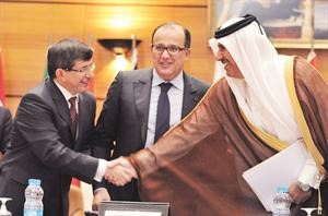 رئيس الوزراء ووزير الخارجية القطري مصافحا وزير خارجية تركيا احمد داود اوغلو بحضور نظيره المغربي طيب الفهري افپ