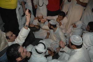 دفيصل المسلم ودجمعان الحربش يجلسان بين المتجمهرين
