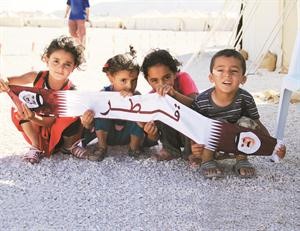 اطفال ليبيون نازحون في مخيم ايواء قطري على الحدود التونسية - الليبية يرفعون العلم القطري عرفانا بما قدمته قطر للثورة والشعب الليبي