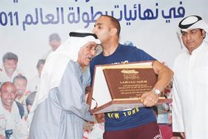 عبد الوهاب العمر يقبل راس اللواء فهد الفهد خلال تسليمه الدرع﻿