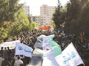 متظاهرون في حي دير بعلبة بمحافظة حمص 	رويترز﻿