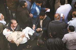 متطوع يحمل مسنا لمساعدته على الادلاء بصوته في القاهرة امس رويترز